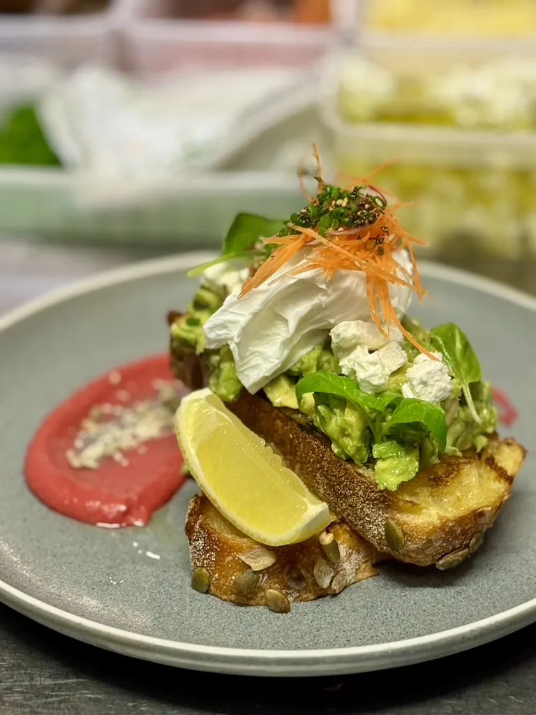 Avocado on toast with feta and a poached egg on pumpkin bread