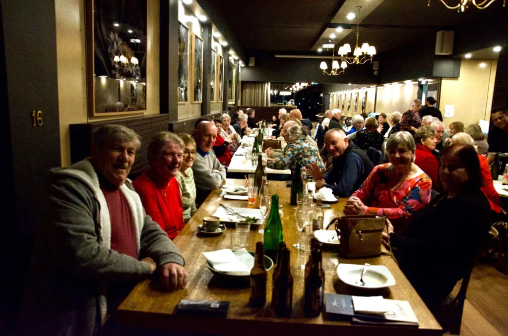 Evening group dinner at long tables in La Baguette's dining room