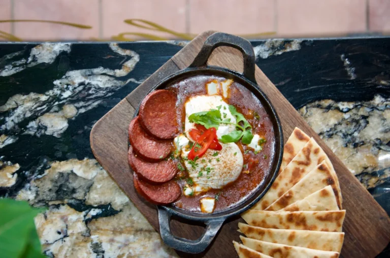 Shakshuka eggs with feta in a cast-iron pan with warm pita