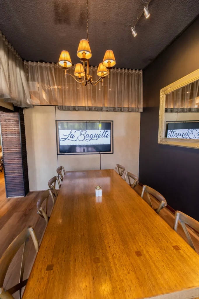 Small private dining room with timber table for 12 and a wall screen